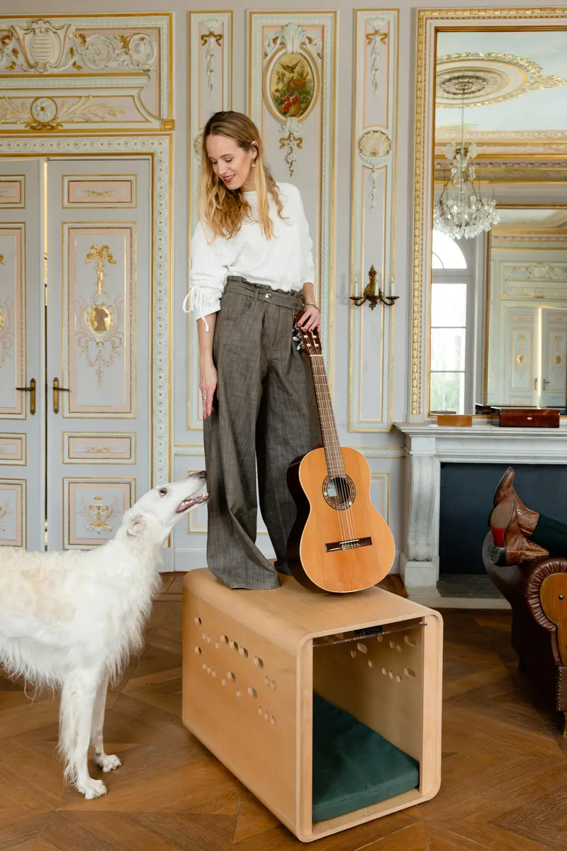 Woman standing on Chest with resting dog inside.